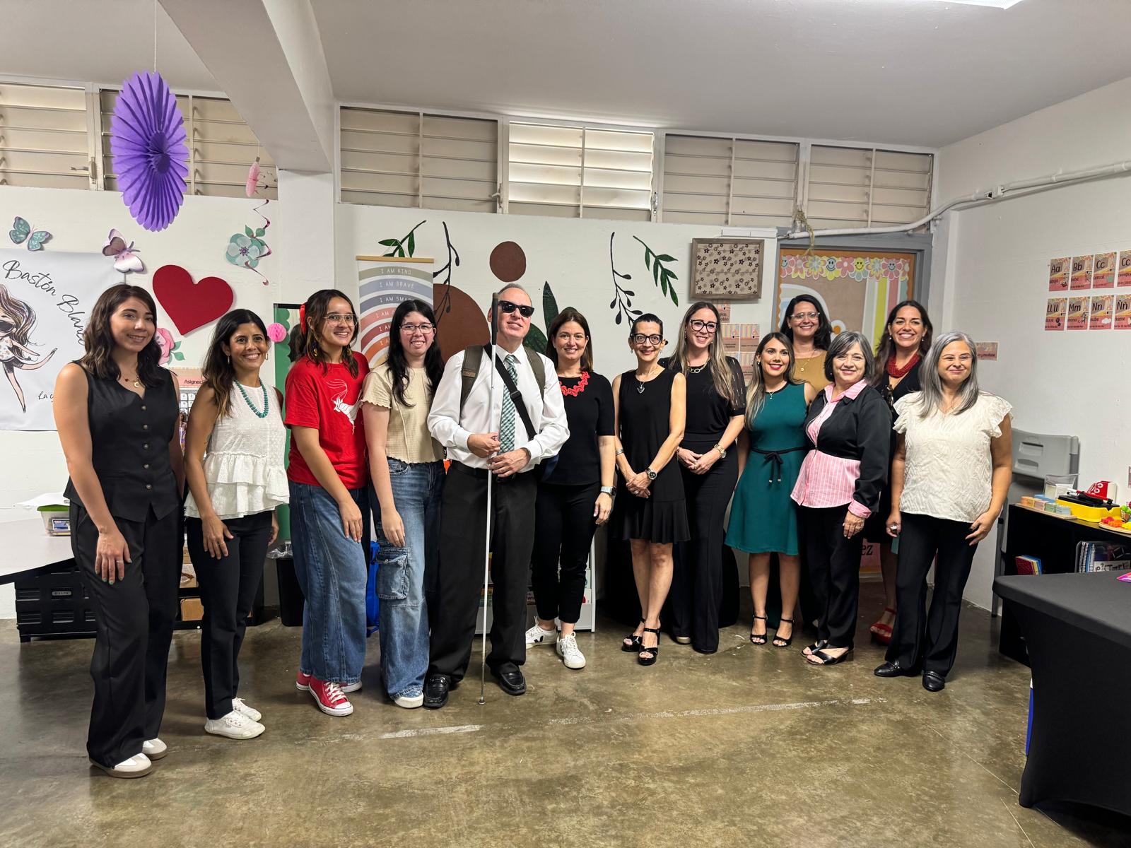 En la foto, Manolo está al lado de la Honorable Maite Oronoz, jueza presidenta del Tribunal Supremo de Puerto Rico. La foto presenta a Manolo junto con invitados a la actividad de la presentación del Espacio Imaginario.