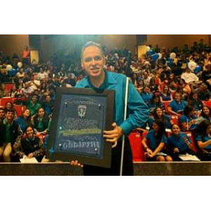 La foto muestra a Manolo posando junto a estudiantes de la Sociedad de Honor del Colegio Maristas en Guaynabo.