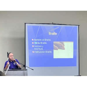 La foto presenta a Manolo en el podio durante su charla.