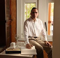Foto de Manolo leyendo libro en Braille. Al lado se encuentra su bastón guía. Foto de Manolo leyendo libro en Braille. Al lado se encuentra su bastón guía.
